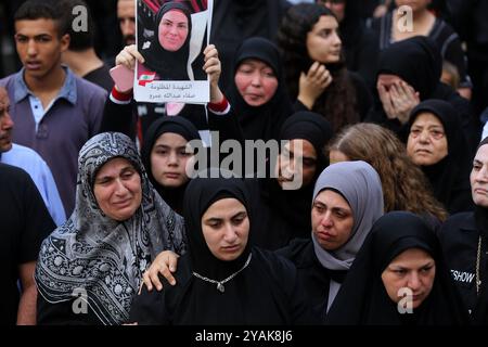 Maaysra, Maaysra, Liban. 14 octobre 2024. Des femmes pleurent lors des funérailles de 10 Libanais, tués lors d'une frappe aérienne israélienne, lors de leur cortège funéraire dans le village de Maaysra, au nord de Beyrouth. Le carnage de la guerre d'Israël avec le Hezbollah pro-iranien, un conflit qui se déroule en parallèle et qui a des liens directs avec la guerre dévastatrice dans la bande de Gaza, s'est poursuivi, faisant des morts des deux côtés de la frontière israélo-libanaise. Crédit : ZUMA Press, Inc/Alamy Live News Banque D'Images