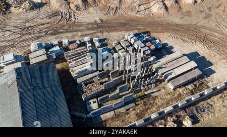 Vue aérienne d'un empilement de vieilles dalles de béton site de stockage, piles de terre, et quelques petits bâtiments. La zone est entourée d'une clôture, et il y a vi Banque D'Images