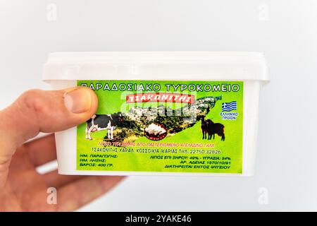 Faros, Grèce - 12 mai 2023 : fromage de vache, produit laitier traditionnel grec Ikarian de la zone bleue de longévité Ikaria main tenant en gros plan Banque D'Images