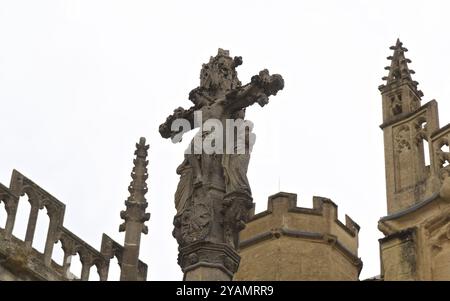Une croix de Jésus en pierre orne l'église historique Jean Baptiste de Cotswold Cirencester Banque D'Images