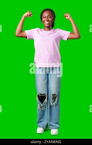 Une jeune femme avec des tresses exprime l'excitation avec un poing serré sur un fond vert vif Banque D'Images