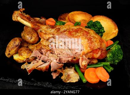 Cuisse de dinde rôtie avec pommes de terre, légumes et puddings Yorkshire Banque D'Images