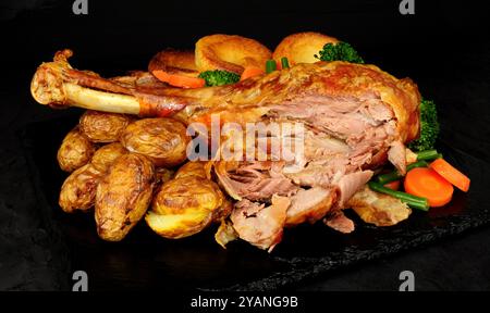 Cuisse de dinde rôtie avec pommes de terre, légumes et puddings Yorkshire Banque D'Images