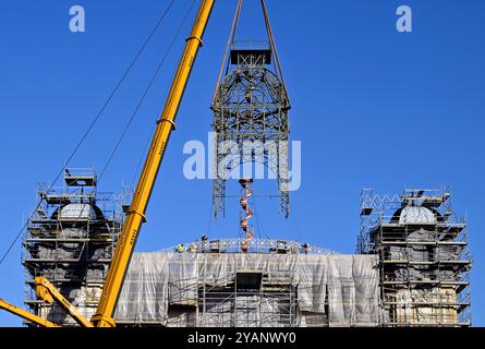 Les ouvriers à l'aide de grues ramènent la tour de l'horloge sur le toit du palais industriel reconstruit sur le parc des expositions de Prague, le 15 octobre 2024. La structure de la tour était en mauvais état et ne pouvait pas être réparée à son emplacement d'origine. Le Palais industriel brûle en 2008. Le coût de la reconstruction devrait être d'environ 2,64 milliards de couronnes tchèques et devrait être achevé en 2024. Les travaux seront réalisés par le consortium Company for the Industrial Palace dirigé par Metrostav. Des difficultés à long terme ont accompagné les efforts d'achèvement. (CTK photo/Katerina Sulova) Banque D'Images