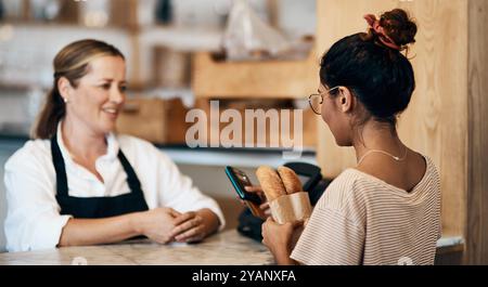 Femme, client ou vente dans la boulangerie avec du pain, des achats ou de la technologie pour l'achat. Personnes, paiement par carte de crédit ou propriétaire dans le café de petite entreprise pour l'épicerie Banque D'Images