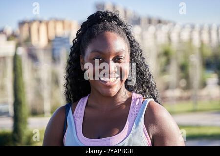 Portrait d'une jeune femme afro-américaine aux cheveux bouclés montrant ses dents blanches Banque D'Images