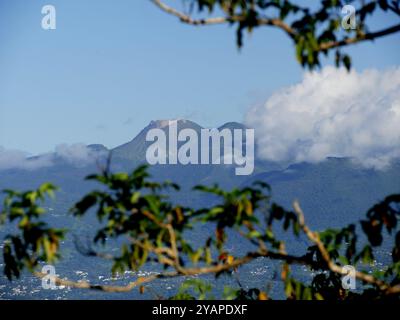 Sommet du volcan Soufrière à Guadaloupe vu des Saintes, à travers des branches d'arbres. Banque D'Images