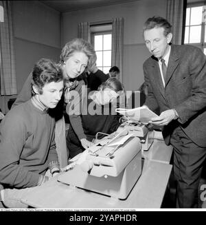 Apprendre à taper dans les années 1960 Une salle de classe d'étudiants assis à des machines à écrire. Une classe et une éducation à la frappe, en utilisant les doigts et les touches droites. Deux professeurs dans la photo. 1968. Conard ref 5573 Banque D'Images