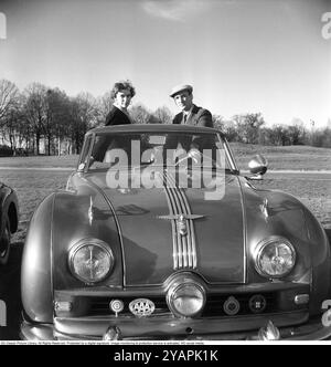 Un fier propriétaire de voiture dans les années 1950 Un homme avec sa petite amie dans sa voiture, une Austin 1950 A 90 Atlantic avec le numéro d'immatriculation A51517. La voiture a été fabriquée par le constructeur automobile britannique Austin. Le modèle était initialement destiné à être vendu sur le marché américain. Il avait un corps ouvert, un cabriolet. La voiture avait un moteur à essence 4 cylindres, 4 vitesses et une propulsion arrière. La voiture avait trois phares. Ce propriétaire de voiture était membre de plusieurs associations automobiles internationales, clubs automobiles et leurs emblèmes sont montés sur le devant de la voiture. Anders Svahn ref SVA13 Banque D'Images