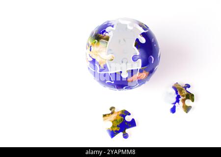 Puzzle globe partiellement complété montrant la Terre, avec quelques pièces manquantes, représentant des défis dans la compréhension du monde. Banque D'Images