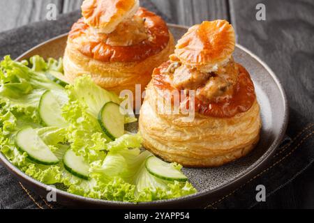 Bouchee d'entrée française farcie de veau à la sauce aux champignons gros plan dans une assiette sur une table en bois. Horizontal Banque D'Images