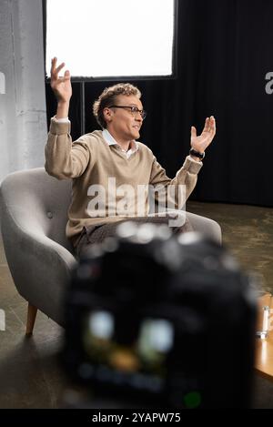 Un journaliste d’âge moyen s’engage dans une interview réfléchie avec un homme, mettant en valeur le dialogue professionnel et l’expertise. Banque D'Images