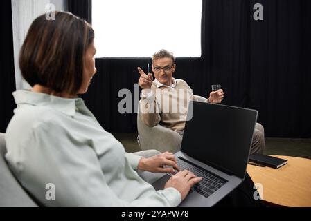 Une journaliste d'âge moyen s'engage dans une interview perspicace avec un spécialiste dans un studio serein. Banque D'Images