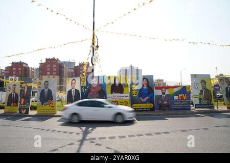 Duhok, Irak. 13 octobre 2024. Une voiture vue passer devant les bannières électorales des candidats avant les élections du Parlement régional du Kurdistan dans la ville de Duhok, en Irak. (Photo de Ismael Adnan/SOPA images/SIPA USA) crédit : SIPA USA/Alamy Live News Banque D'Images