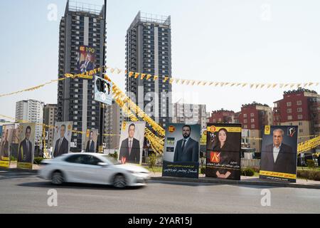 Duhok, Irak. 13 octobre 2024. Une voiture vue passer devant les bannières électorales des candidats avant les élections du Parlement régional du Kurdistan dans la ville de Duhok, en Irak. (Photo de Ismael Adnan/SOPA images/SIPA USA) crédit : SIPA USA/Alamy Live News Banque D'Images