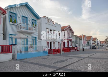 Rue touristique portugaise avec ses maisons emblématiques rayées et colorées. Fin de journée. Costa Nova do Prado, Aveiro, Portugal - août 2024 Banque D'Images