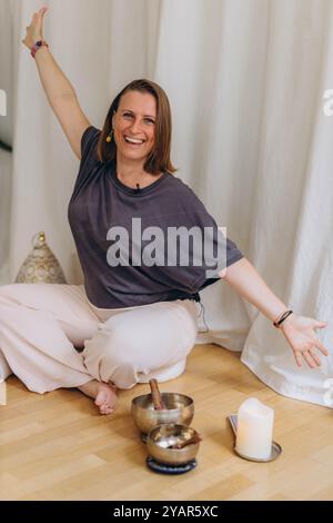 Une femme heureuse après une pratique de bol de respiration et de chant. Photo de haute qualité Banque D'Images