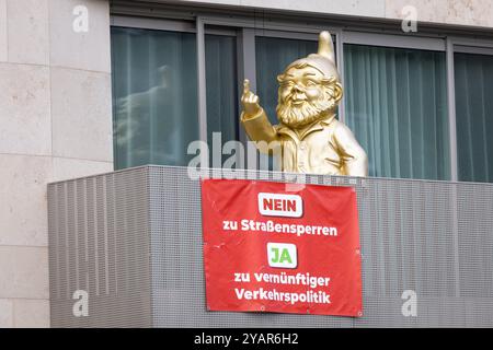 Protestation für vernünftige Verkehrspolitik Ein Plakat mit der Aufschrift NEIN zu Straßensperren JA zu hängt Verkehrspolitik vernünftiger an einem Balkon in Frankfurt am main, auf dem sich ein goldener, übergroßer Gartenzwerg befidnet. Francfort-sur-le-main Hessen Deutschland *** protestation pour une politique de circulation raisonnable Une affiche indiquant NON aux fermetures de routes OUI à une politique de circulation raisonnable est accrochée sur un balcon à Francfort-sur-le-main avec un gnome de jardin surdimensionné et doré Francfort-sur-le-main Hesse Allemagne 2024-10-15 verkehrspolitik 02 Banque D'Images