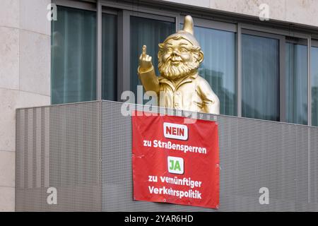 Protestation für vernünftige Verkehrspolitik Ein Plakat mit der Aufschrift NEIN zu Straßensperren JA zu hängt Verkehrspolitik vernünftiger an einem Balkon in Frankfurt am main, auf dem sich ein goldener, übergroßer Gartenzwerg befidnet. Francfort-sur-le-main Hessen Deutschland *** protestation pour une politique de circulation raisonnable Une affiche indiquant NON aux fermetures de routes OUI à une politique de circulation raisonnable est accrochée sur un balcon à Francfort-sur-le-main avec un gnome de jardin surdimensionné et doré Francfort-sur-le-main Hesse Allemagne 2024-10-15 verkehrspolitik 01 Banque D'Images