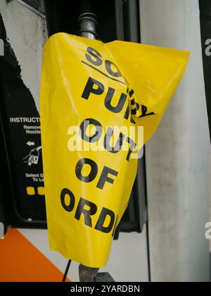 Jaune Désolé pompes hors service envelopper la poignée de pompe d'une station-service avec une police noire. Vue verticale gros plan. Notification de panne de gaz. Banque D'Images