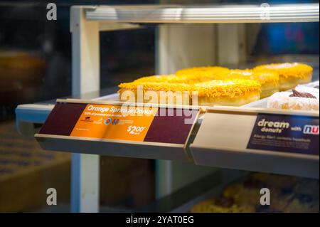 Photo d'une vitrine de boulangerie avec des beignets à l'ancienne saupoudrer d'orange et une affiche sur le produit des dons dans un restaurant Tim Horton's le jour de la vérité et de la réconciliation Banque D'Images