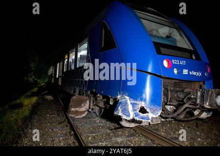 Namborn, Allemagne. 15 octobre 2024. Le wagon motorisé d'un train express régional vlexx se trouve à côté des rails dans la voie ferrée. Le rocher qui a causé l'accident est couché à côté. Le train régional est entré en collision avec le gros rocher sur la voie et a déraillé sur la voie ouverte. Crédit : Laszlo Pinter/dpa/Alamy Live News Banque D'Images