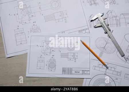 Différents dessins techniques, pied à coulisse et crayon sur table en bois, vue de dessus Banque D'Images