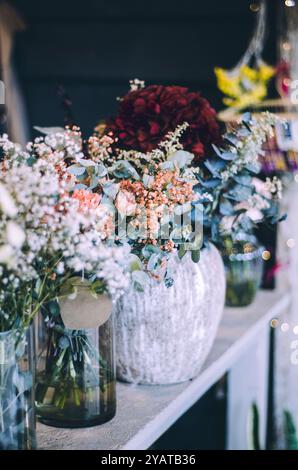 Gros plan des bouquets chics de fleurs de saison dans l'affichage de magasin de fleurs Banque D'Images