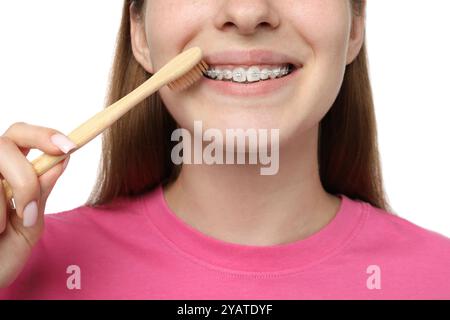 Fille avec des accolades nettoyant les dents sur fond blanc, gros plan Banque D'Images