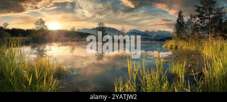 Paysage de Dreamland sur un lac peint au coucher du soleil avec un ciel spectaculaire coloré. Les couleurs magnifiques des nuages se reflètent dans l'eau claire. Banque D'Images