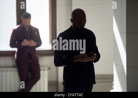 Bucarest, Roumanie. 15 octobre 2024 : Andrew Tate (R) et son frère Tristan Tate (l) attendent pour entrer dans la salle d'audience de la Cour d'appel de Bucarest. Crédit : Lucian Alecu/Alamy Live Nouveau Banque D'Images