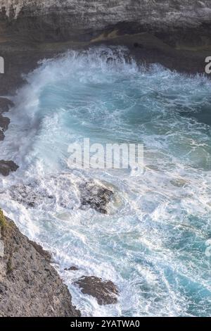 Une vue d'en haut de la plage de Kelingking à Nusa Penida, en Indonésie, révèle un paysage magnifique où les eaux turquoises cristallines rencontrent des eaux de sable blanc Banque D'Images