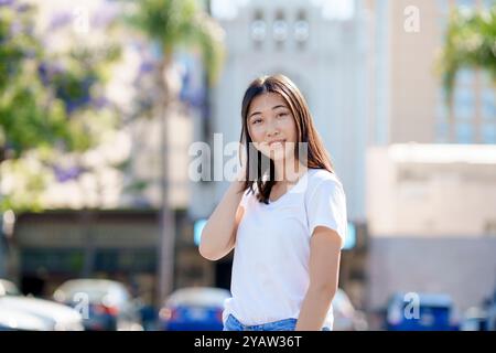 Heureux jeune belle femme asiatique debout demi corps souriant t-shirt jeans Downtown Banque D'Images