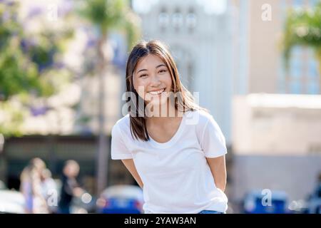 Heureux jeune belle femme asiatique debout demi corps souriant t-shirt jeans Downtown Banque D'Images