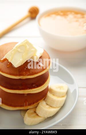 Assiette avec de délicieuses crêpes à la banane sur fond blanc. Photo verticale. Vue de dessus Banque D'Images