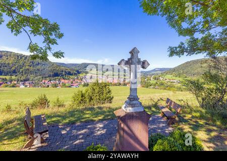 Une fenêtre barrée dans un mur de pierre encadre une vue paisible sur les collines verdoyantes, les champs et les forêts lointaines pendant la journée Banque D'Images