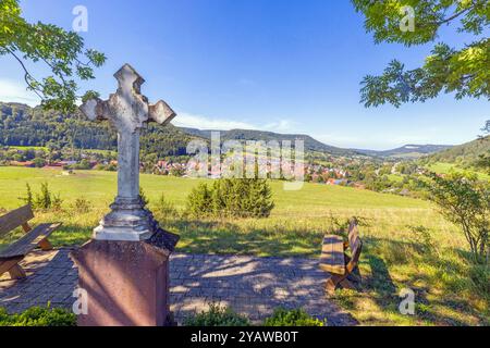 Une fenêtre barrée dans un mur de pierre encadre une vue paisible sur les collines verdoyantes, les champs et les forêts lointaines pendant la journée Banque D'Images