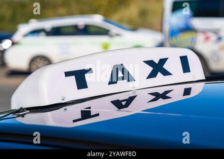 Panneau de taxi sur le dessus d'un taxi ou d'une voiture de location privée Banque D'Images