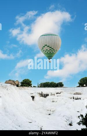 Montgolfière au-dessus des piscines naturelles de travertin et des terrasses à Pamukkale Banque D'Images