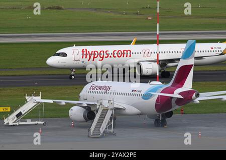 Duesseldorf, Deutschland. 15 octobre 2024. Un Airbus 321 de Pegasus Airlines roule vers le terminal après l'atterrissage, devant un Airbus d'Eurowings dans une position de stationnement, aéroport de Duesseldorf, 15 octobre 2024. Crédit : dpa/Alamy Live News Banque D'Images