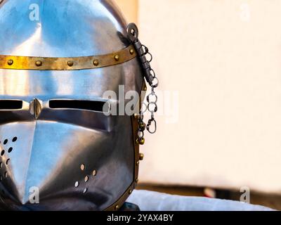 gros plan d'un casque médiéval en métal d'un côté et d'une bannière blanche vierge en arrière-plan. EQUIPEMENT de guerre médiévale avec espace de copie vierge Ar Banque D'Images