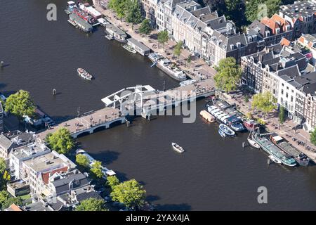 Une journée d'été avec des bateaux et des sloops sur les canaux d'Amsterdam sur la rivière Amstel. Temps ensoleillé et arbres verts et péniches le long du rivage. pays-bas hors service - belgique hors service Banque D'Images