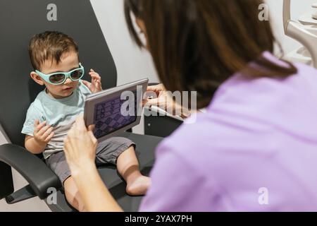 Optométriste pédiatrique examinant les yeux du bébé garçon en clinique Banque D'Images