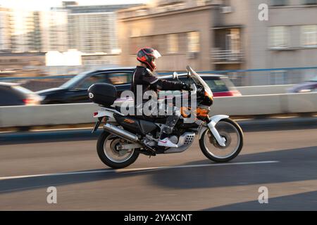 Belgrade, Serbie - 10 octobre 2024 : jeune motocycliste conduisant une moto dans la rue de la ville par une journée ensoleillée Banque D'Images