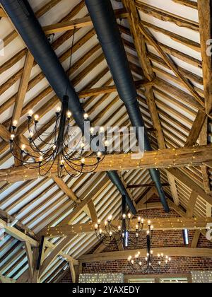 Regardant vers le haut la construction massive de toit intérieur en bois restauré dans une grande ancienne grange. Une photo de téléphone portable avec un post-traitement de téléphone ou de tablette. Banque D'Images