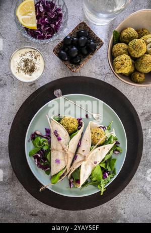 Un délicieux emballage de falafel rempli de légumes frais et garni d'une sauce savoureuse, parfait pour un repas sain Banque D'Images