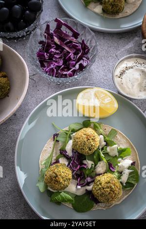 Un délicieux emballage de falafel rempli de légumes frais et garni d'une sauce savoureuse, parfait pour un repas sain Banque D'Images