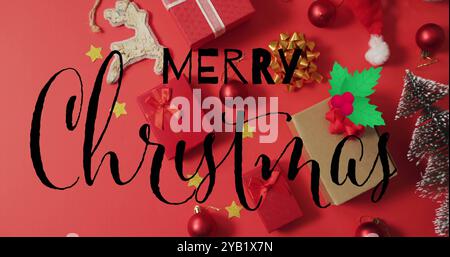 Image de joyeux texte de noël sur des décorations de noël sur fond rouge. Noël, festivité, célébration et concept de tradition génèrent numériquement Banque D'Images