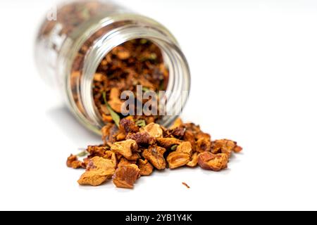 Une boîte de thé de Noël à la pomme à la cannelle est ouverte et son contenu est dispersé sur un fond blanc. Le concept d'abondance et de variété comme le thé vient Banque D'Images