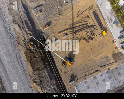Travaux de construction au bord de la mer. La machinerie lourde travaille à renforcer les fondations de l'eau et des vagues de tempête. Vue depuis le drone. Banque D'Images